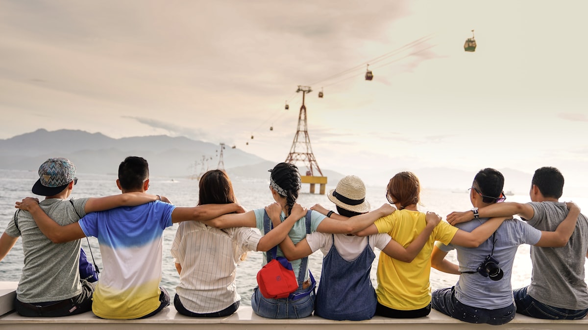 People sitting together by the water, arms around one another — reconnecting and self-care as part of daily recovery