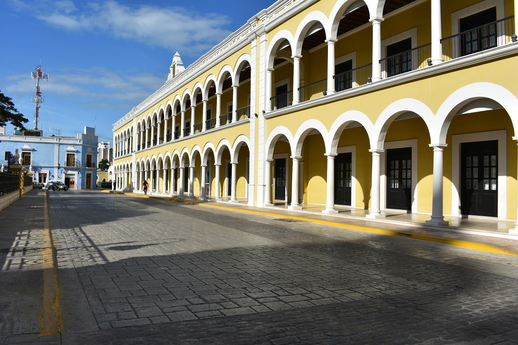 Las Bóvedas in Campeche — a perfectly preserved yellow colonial arcade with white archways in the city's walled historic center.